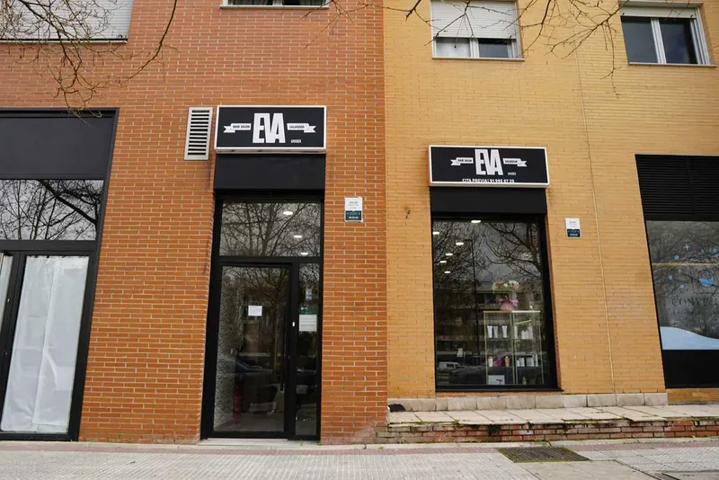 La fachada: dos rótulos negros con la palabra EVA sobre la puerta y el escaparate