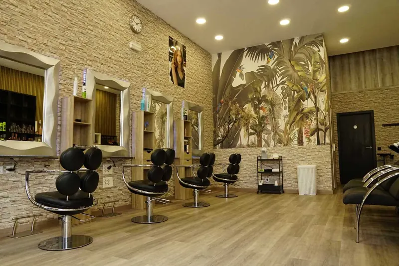 La sala: cuatro tocadores con espejos plateados, sillones negros y el mural de palmeras al fondo